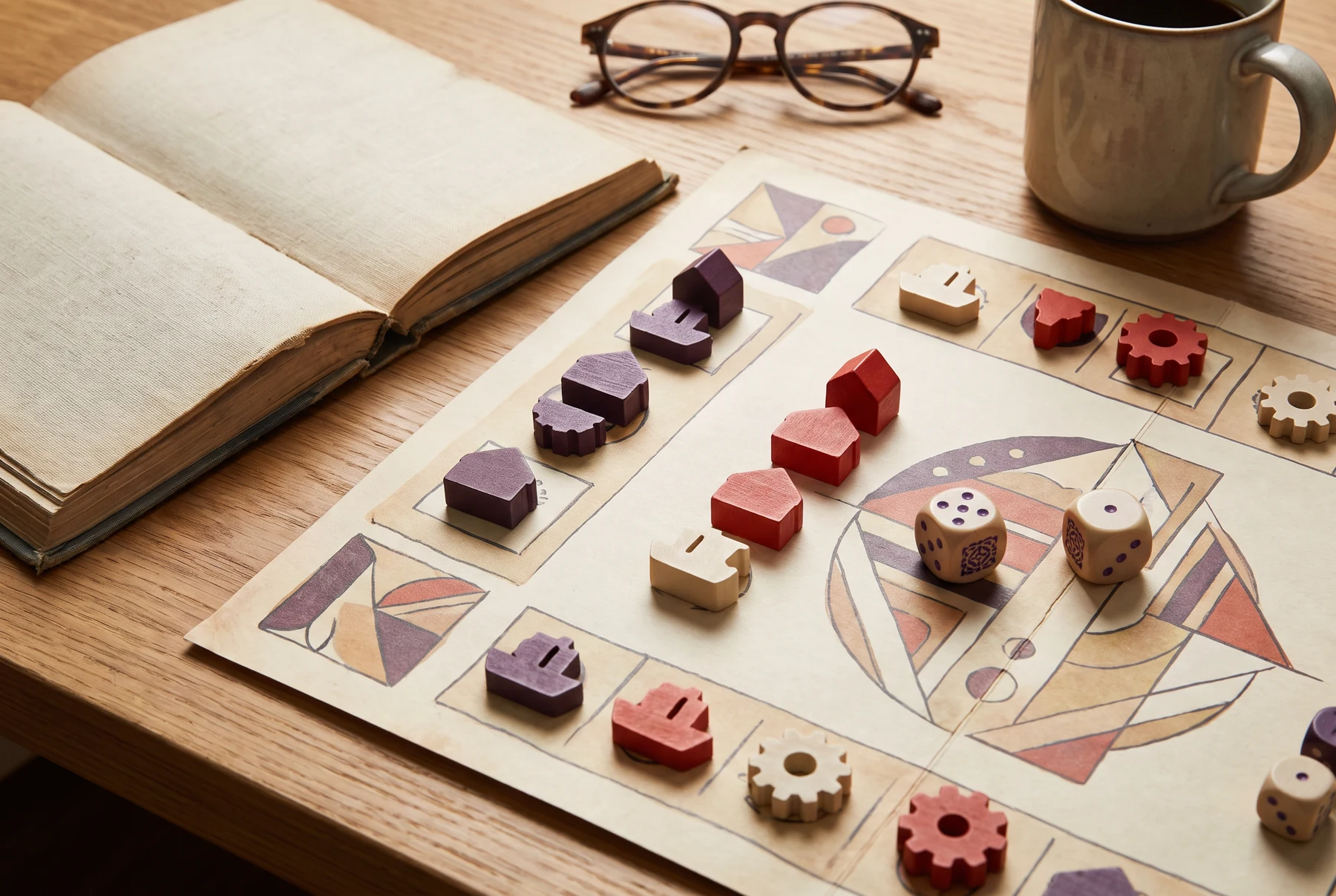 A tabletop game board with geometric artwork, dice, and wooden pieces