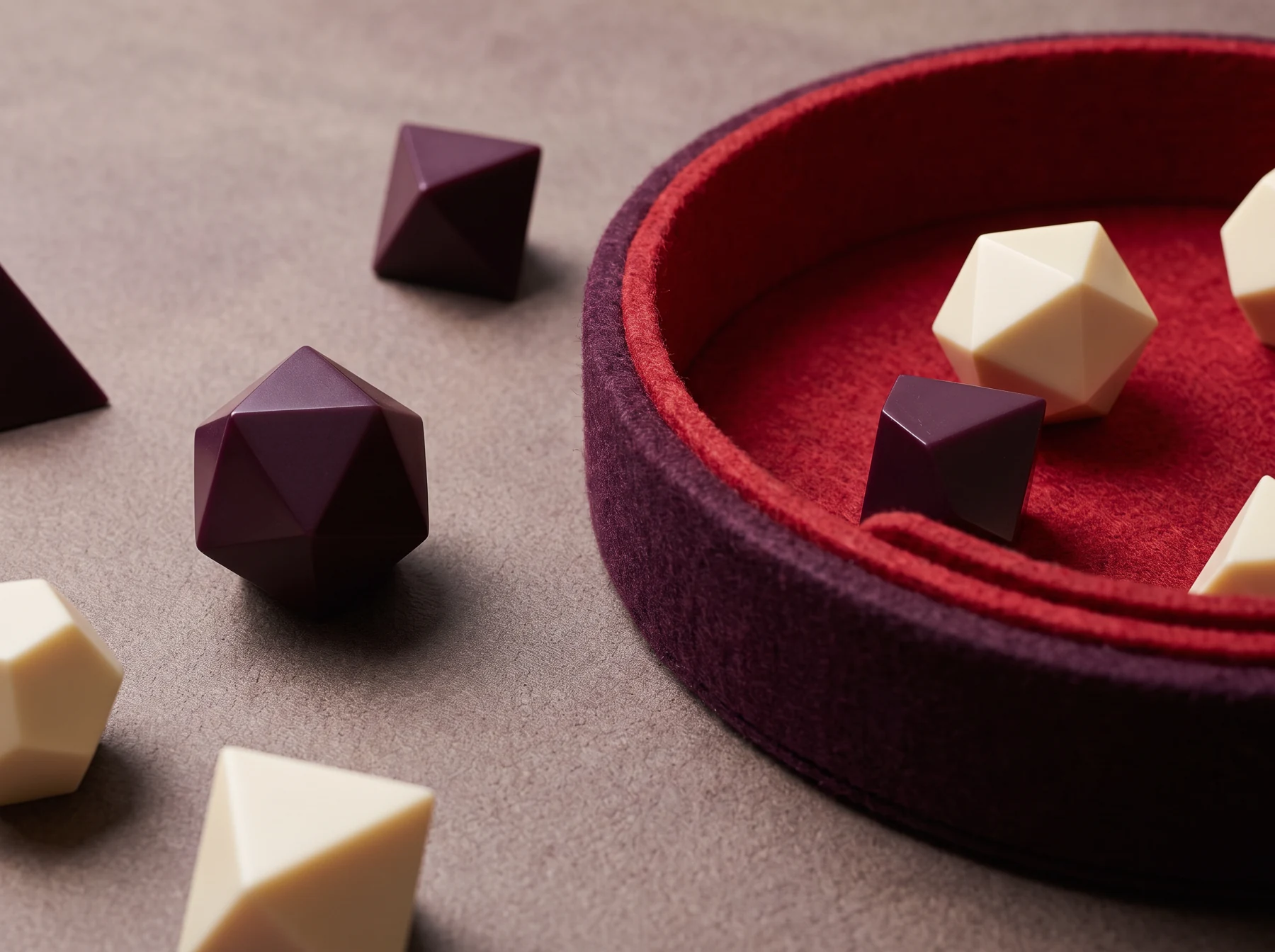 Polyhedral game dice beside a red velvet dice tray
