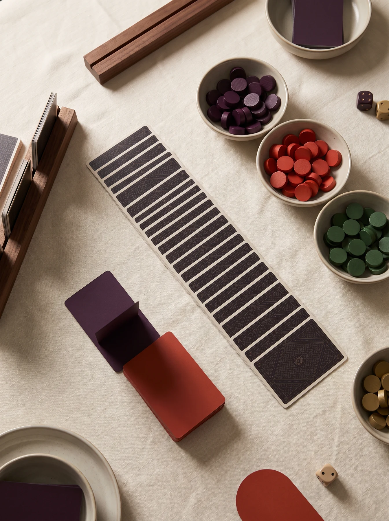 Cards, colorful tokens, and game pieces arranged on a pale cloth